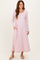 woman wearing a light pink long sleeve maxi dress with side pockets and a relaxed fit
