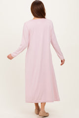 woman wearing a long pink maxi dress with long sleeves, viewed from the back