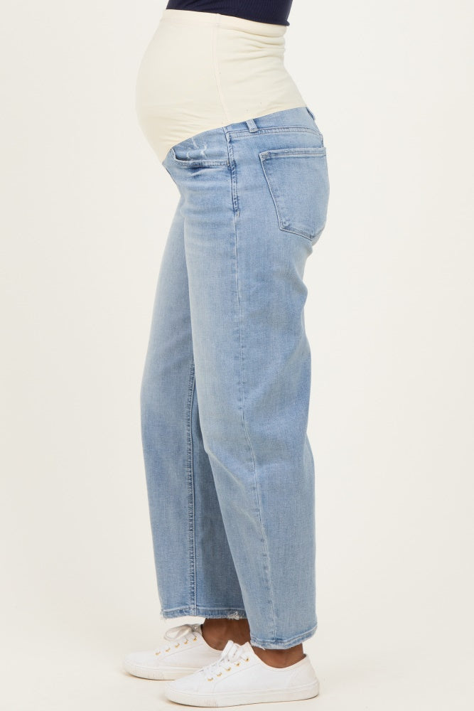 woman wearing light blue maternity jeans with a visible baby bump