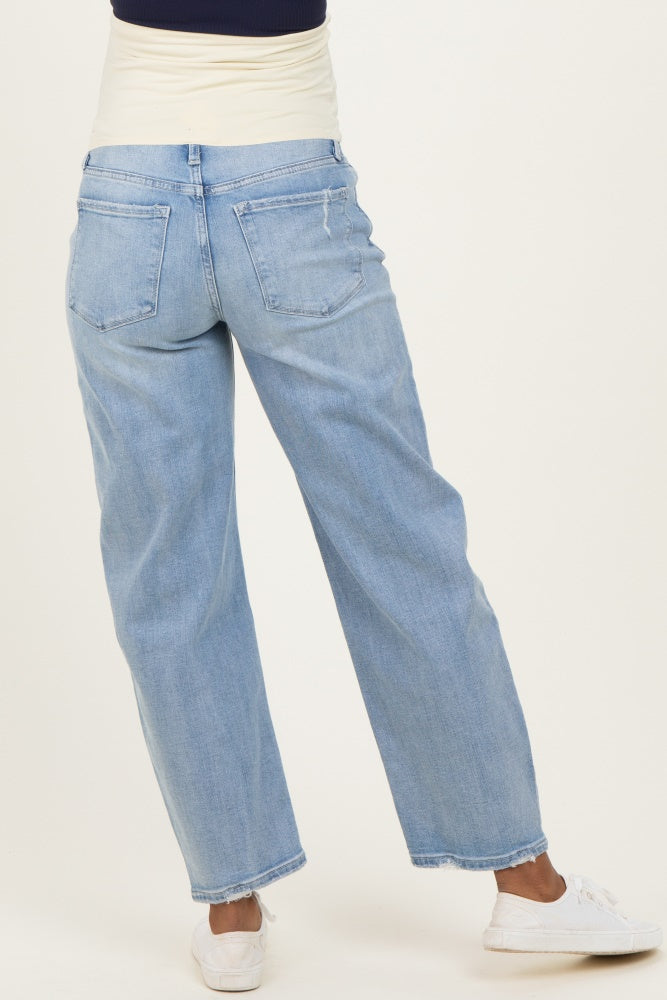 woman wearing light blue maternity jeans with a relaxed fit and rolled cuffs