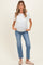 woman wearing a white short sleeve maternity top and blue jeans, holding her baby bump