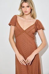 woman wearing a rust-colored maxi dress with short puff sleeves and a v-neckline