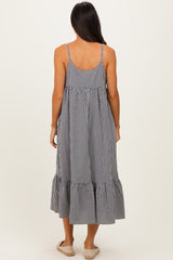 woman wearing a black and white gingham maxi dress with a ruffled hem and adjustable straps, shown from the back