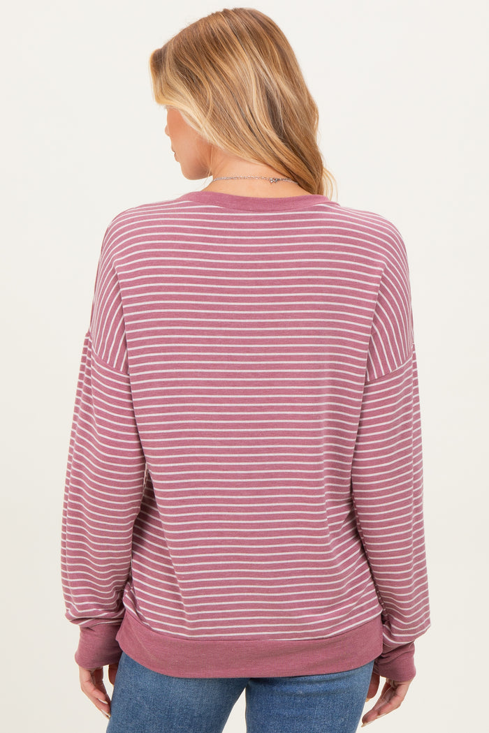 woman wearing a mauve and white striped maternity sweatshirt with a relaxed fit seen from the back