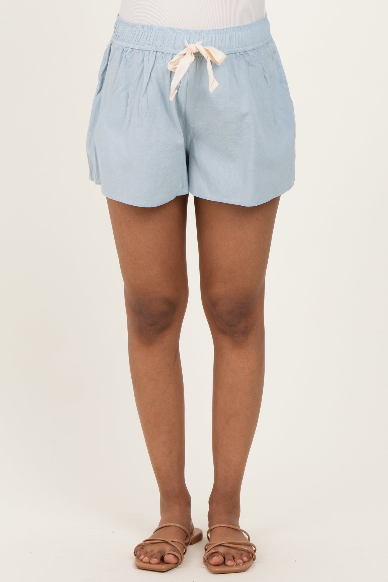 woman wearing light blue maternity shorts with drawstring waistband and side pockets
