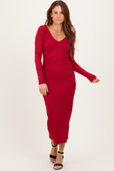 woman wearing a red ribbed long sleeve midi dress with a v-neckline and a fitted silhouette