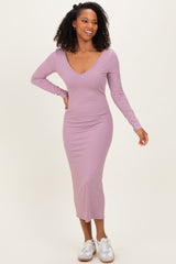 woman wearing a light purple ribbed long sleeve midi dress with a deep v-neckline and white sneakers.