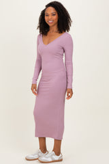 woman wearing a light mauve ribbed long sleeve dress with a v-neckline and a fitted silhouette
