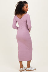 woman wearing a light purple ribbed long sleeve dress with a v-back and a fitted silhouette