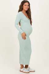 woman wearing a mint green long sleeve maternity dress with a fitted silhouette and baby bump visible