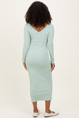 woman wearing a light mint green long sleeve ribbed maxi dress, view from the back