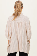 woman wearing a light beige maternity top with vertical stripes and a loose, oversized fit seen from the back