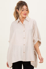 woman wearing a cream striped maternity shirt with a loose fit and button-down front, highlighting a visible baby bump