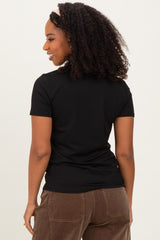 woman wearing a black short sleeve fitted top, viewed from the back, with curly hair and a headband