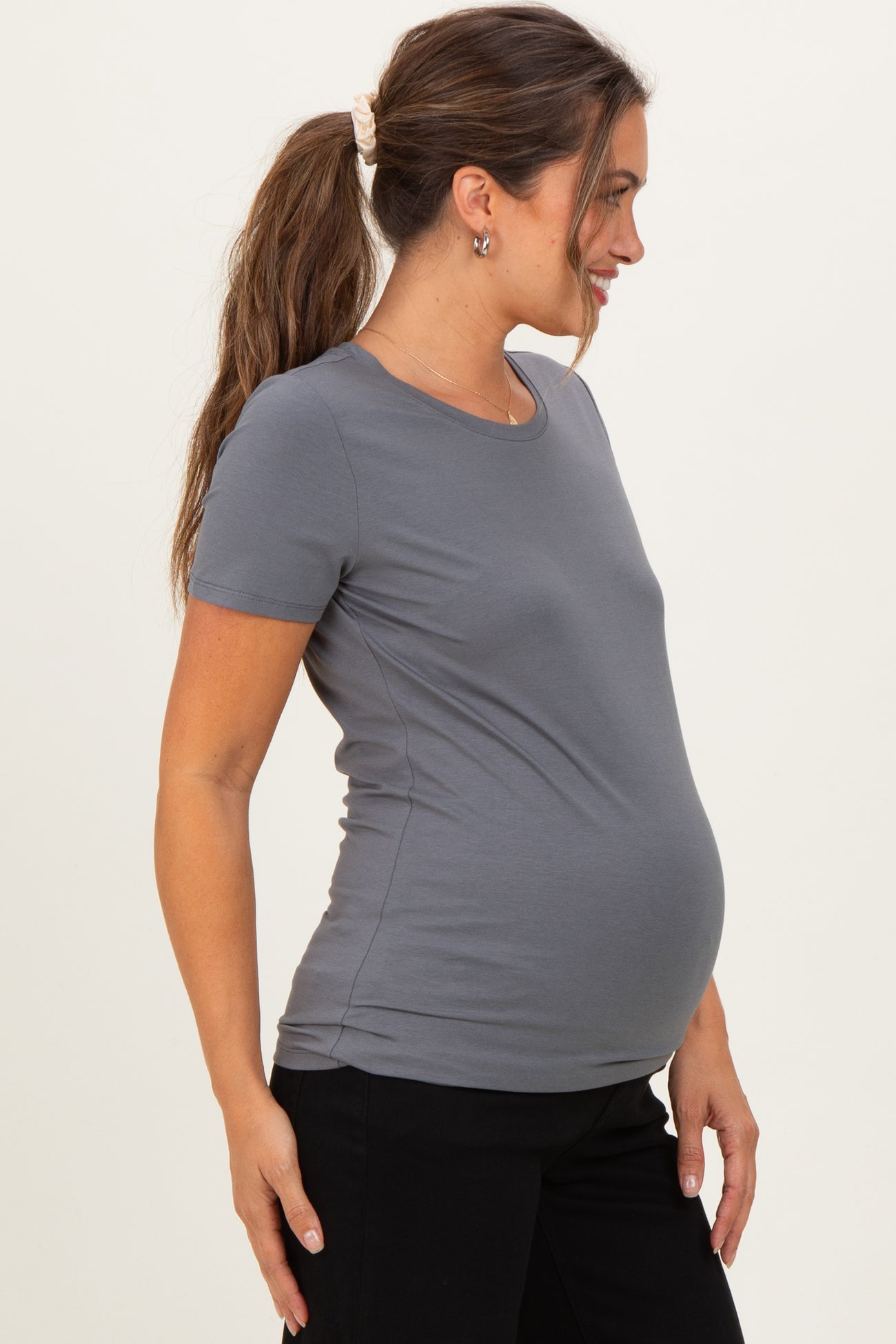 woman wearing a grey short sleeve maternity t-shirt, showing a visible baby bump