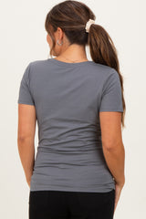 woman wearing a dark grey short sleeve maternity top, showing the back design and fit