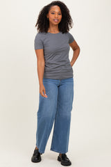 woman wearing a gray short sleeve t-shirt and high-waisted blue wide-leg jeans