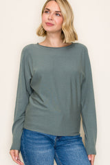 woman wearing a green long sleeve sweater and blue jeans