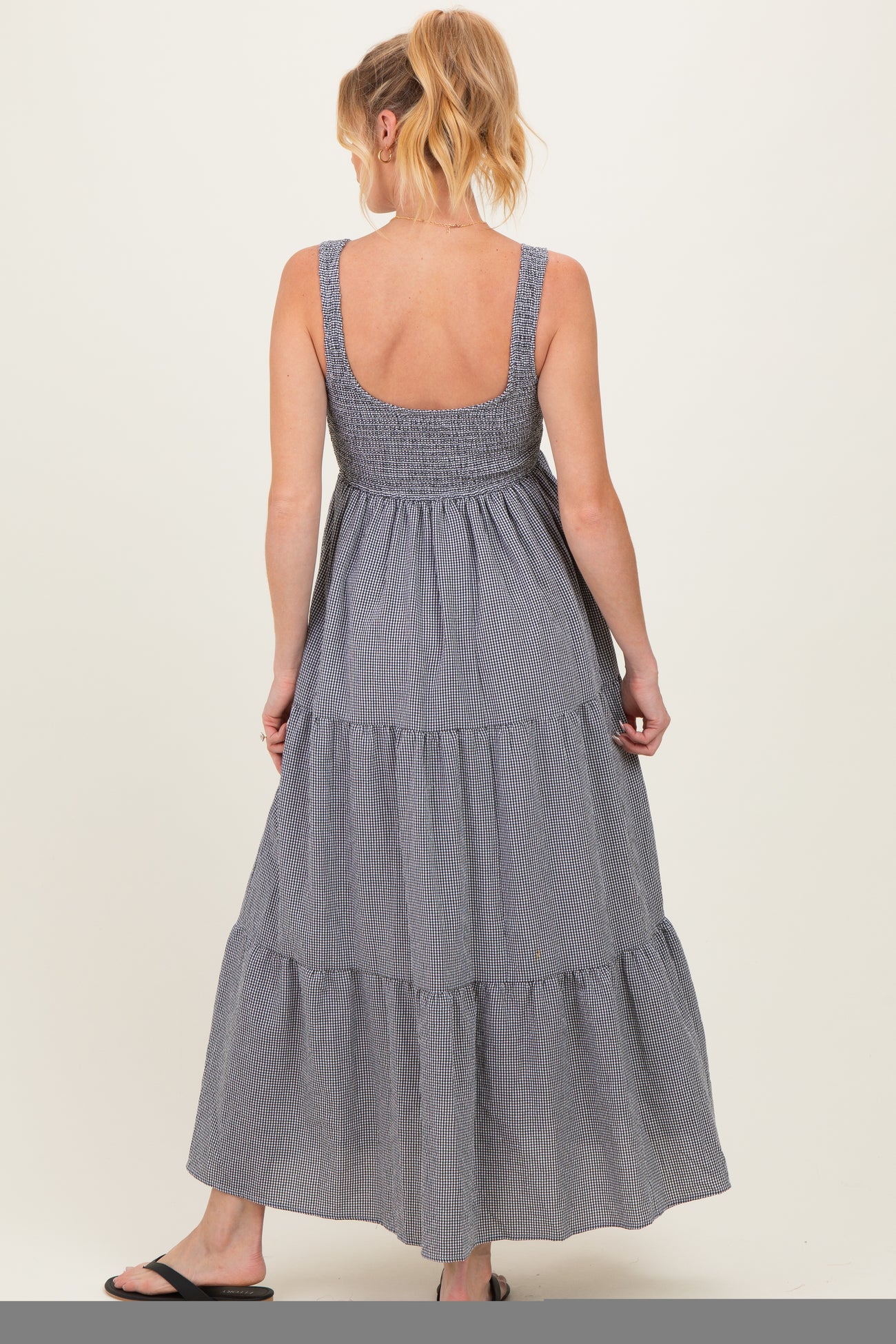 woman wearing a navy and white striped maternity maxi dress with a smocked bodice and tiered hem
