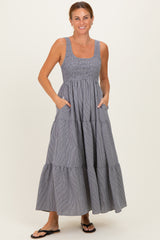 woman wearing a navy and white striped maxi dress with a smocked bodice and pockets