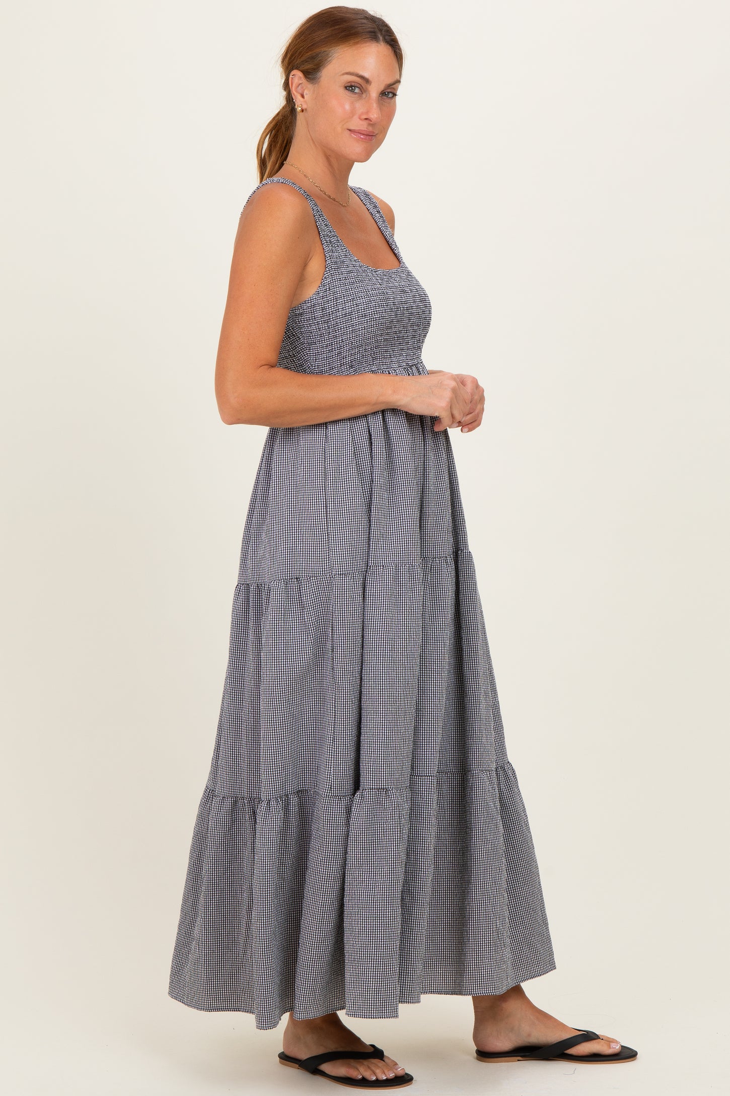 woman wearing a navy and white striped tiered maxi dress with a fitted bodice and wide straps