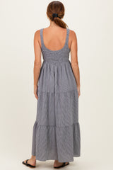 woman wearing a back view of a striped maxi dress with adjustable straps and tiered design
