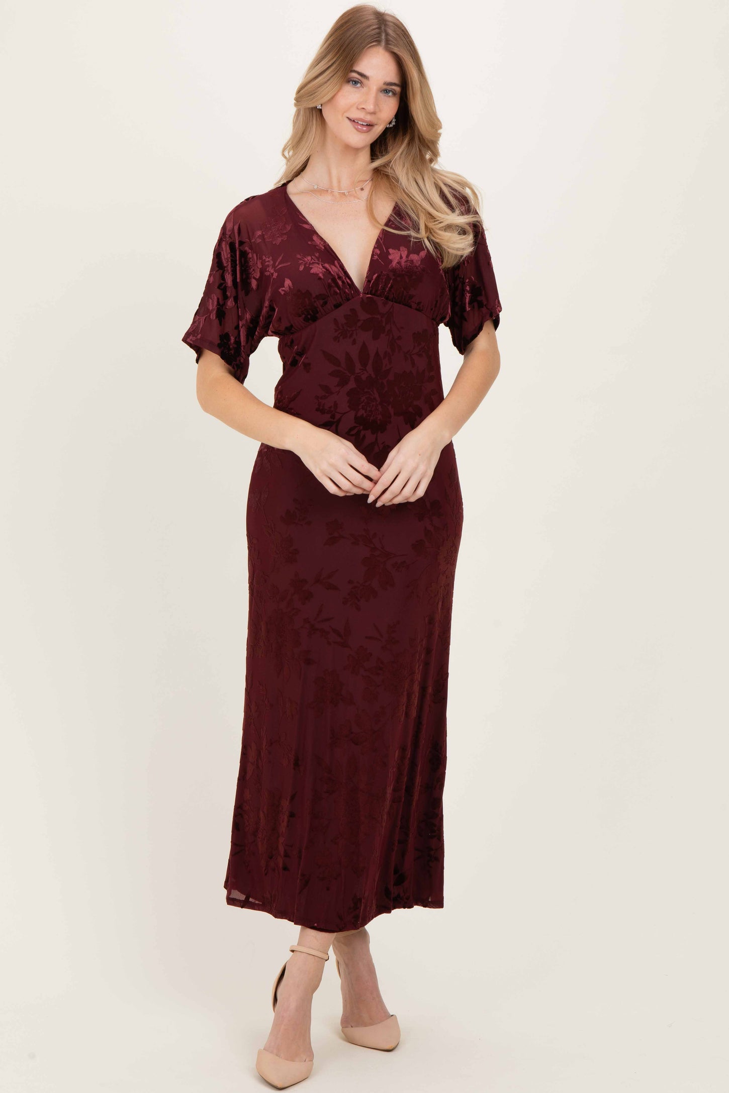 woman wearing a burgundy floral wrap dress with short sleeves and a deep v-neckline