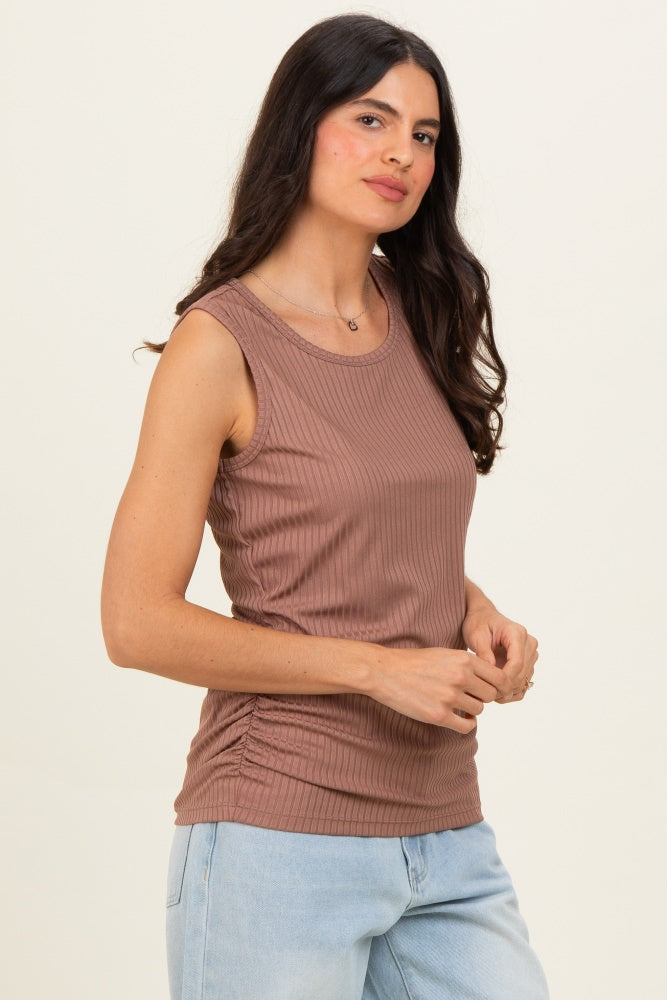 woman wearing a mauve sleeveless ribbed top with side ruching and styled with light wash jeans