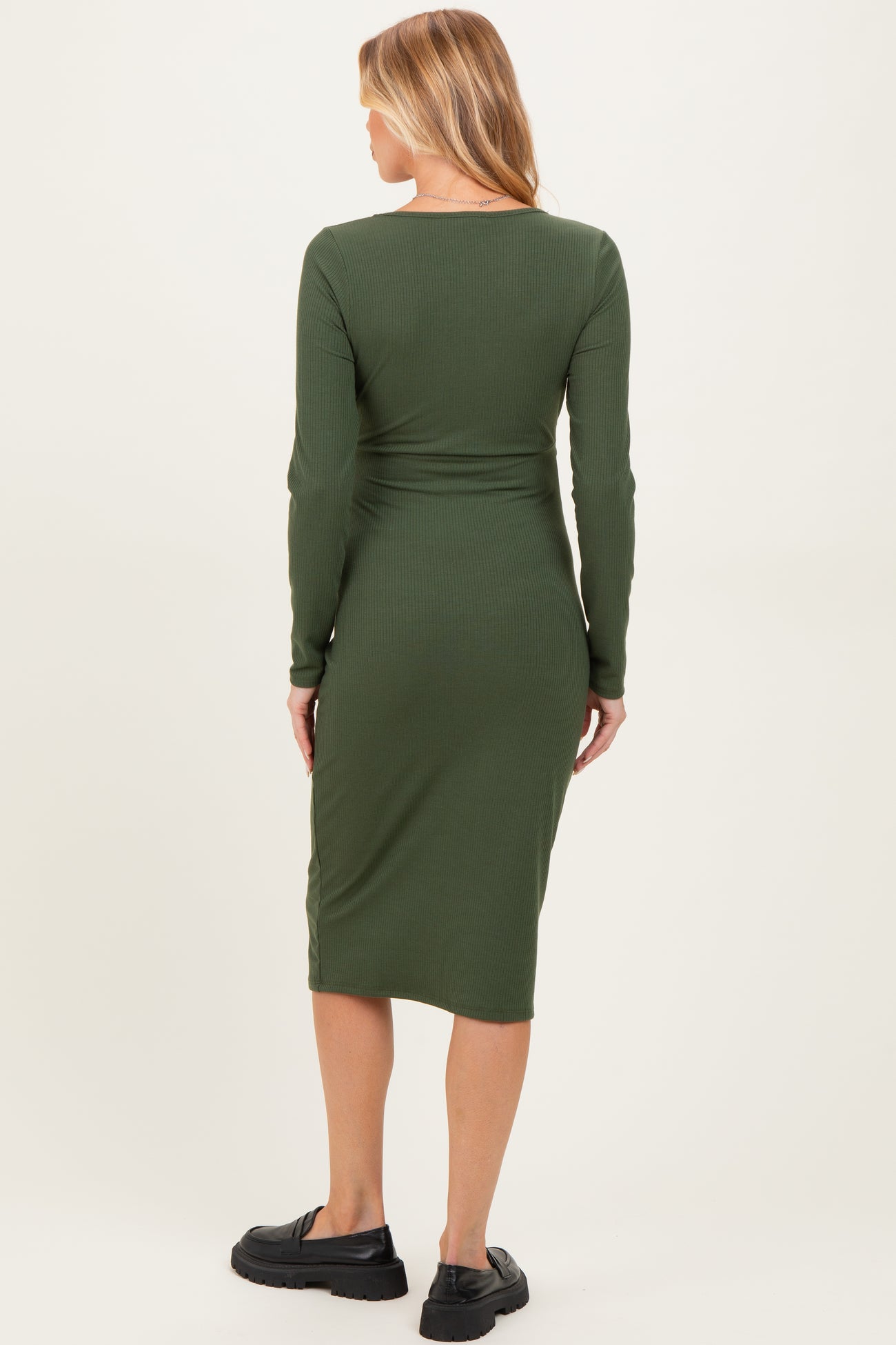 woman wearing a dark green long sleeve maternity dress with a fitted silhouette and back view of the dress