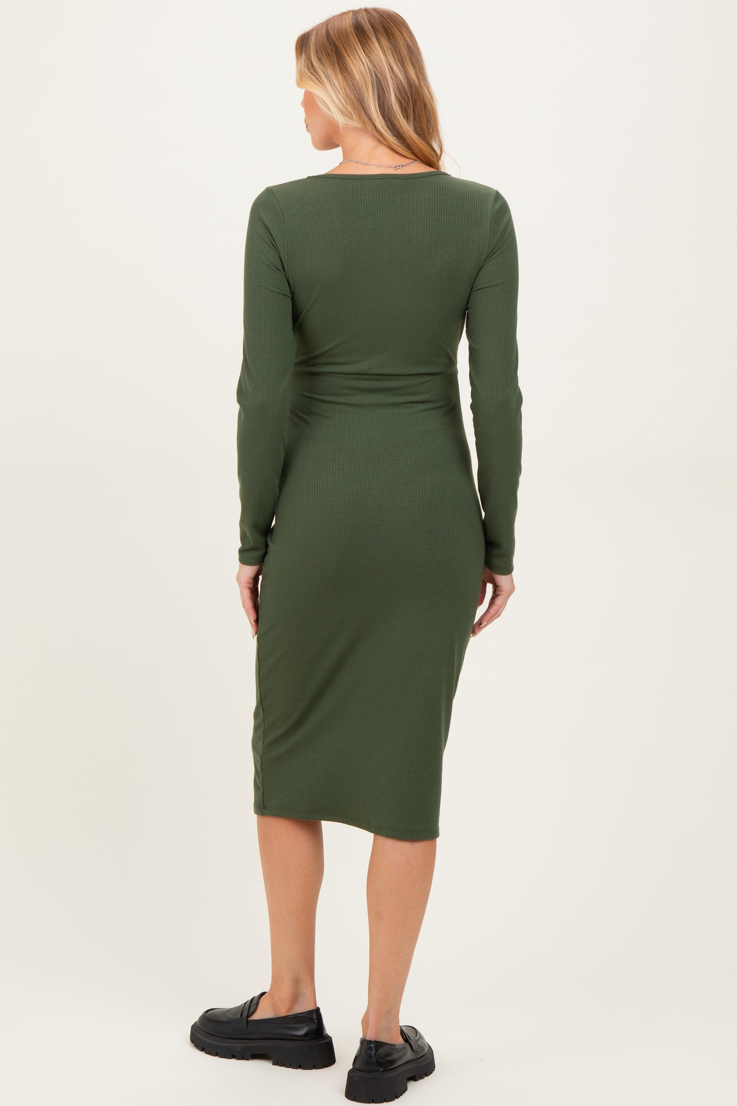 woman wearing a dark green long sleeve maternity dress with a fitted silhouette and back view of the dress