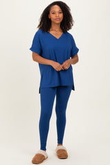 woman wearing a blue short sleeve v-neck top and matching blue leggings, styled with cozy slippers