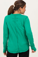 woman wearing a green long sleeve maternity top, showing a stylish back with stitched detail and relaxed fit