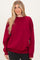 woman wearing a burgundy oversized sweatshirt with a crew neckline and long sleeves