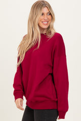 woman wearing a burgundy oversized sweatshirt with long sleeves and a relaxed fit