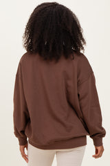 woman wearing a brown oversized sweatshirt with long sleeves and a relaxed fit, viewed from the back
