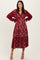 woman wearing a burgundy lace tiered maxi dress with long sleeves and a v-neckline
