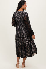 woman wearing a black lace maternity dress with long sleeves, showing a flowing silhouette and back detail