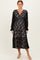 woman wearing a black lace long sleeve wrap dress with a tiered skirt and a v-neckline