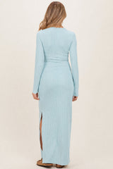 woman wearing a light blue ribbed maternity maxi dress with long sleeves and side slits, viewed from the back