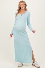 woman wearing a light blue ribbed long sleeve maternity dress with a side slit and showing her baby bump