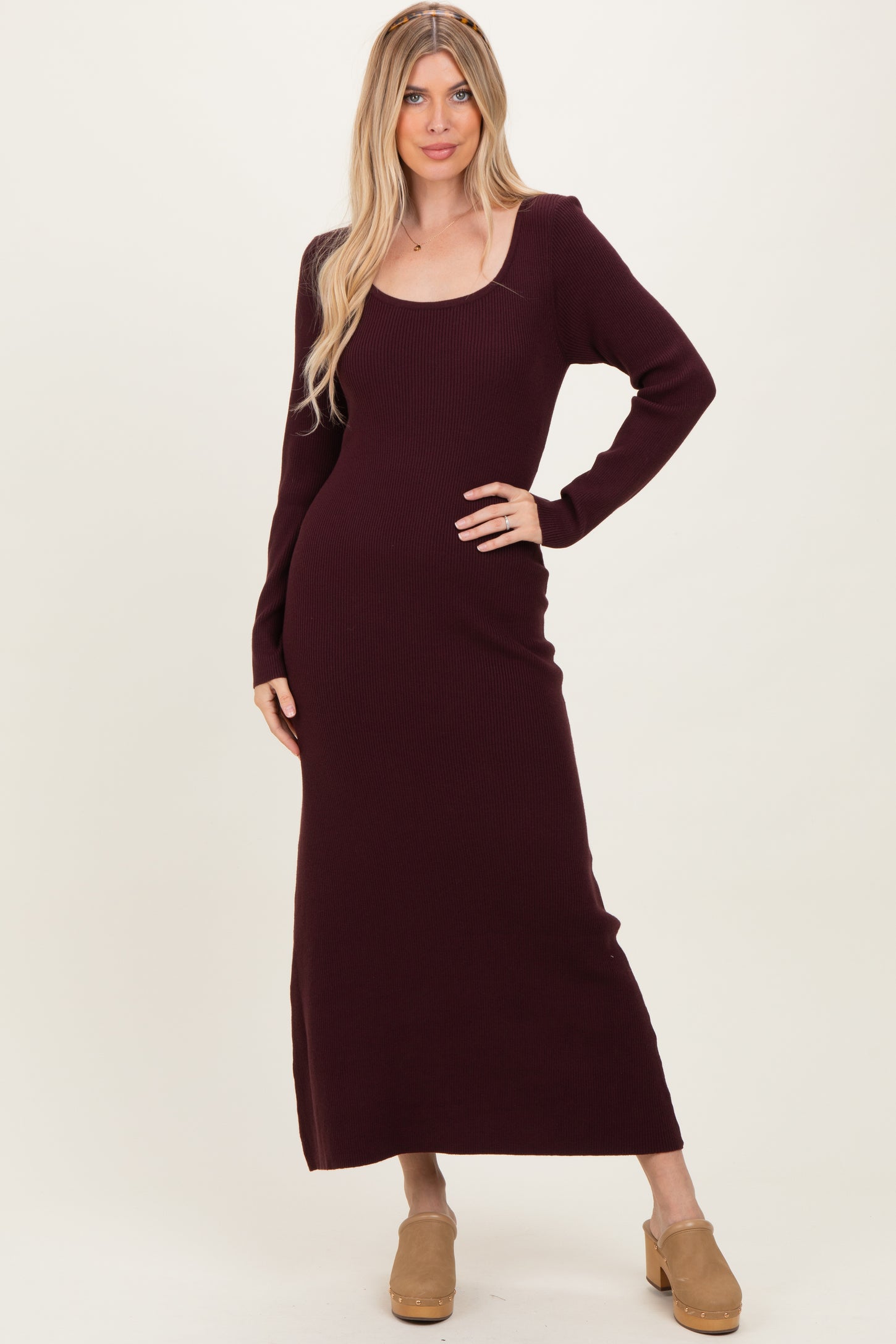 woman wearing a burgundy ribbed long sleeve maxi dress with side slits and beige platform shoes