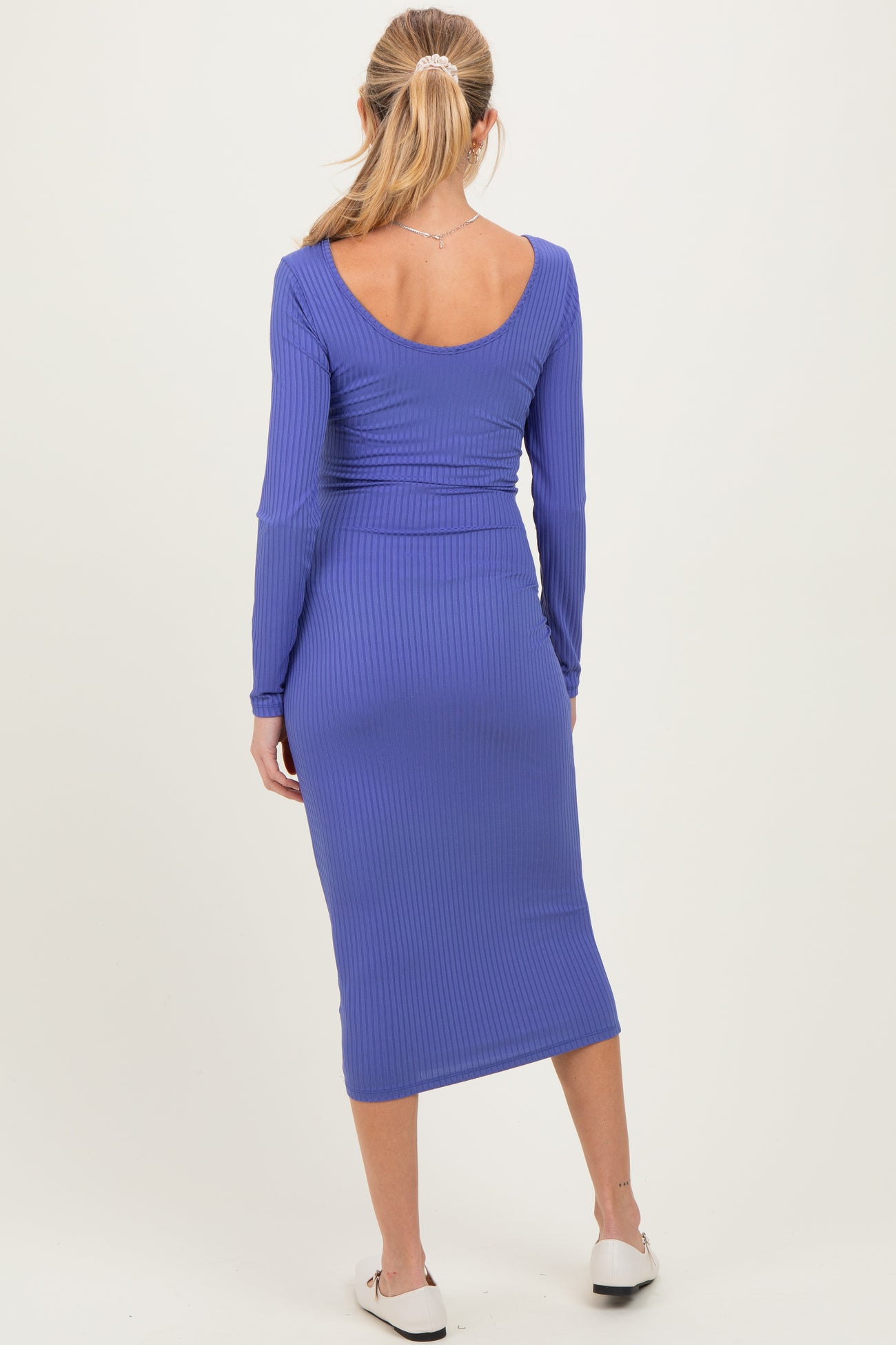 woman wearing a purple long sleeve maternity dress with a fitted ribbed design, showing a baby bump from the back