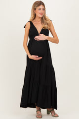 woman wearing a black maternity maxi dress with ruffle straps and a baby bump visible