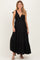 woman wearing a black striped maternity maxi dress with tiered ruffle detail and adjustable tie straps, showing baby bump