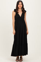 woman wearing a black striped maxi dress with tie shoulder straps and a tiered skirt