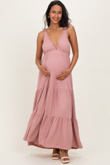 woman wearing a pink striped maternity maxi dress and holding her baby bump