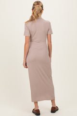 woman wearing a beige ribbed maternity maxi dress, showing the back view with short sleeves and a fitted silhouette