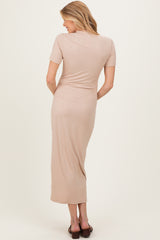 woman wearing a beige ribbed maternity dress with a fitted style and short sleeves, showing her back