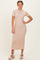 woman wearing a beige ribbed midi dress with short sleeves and a bodycon fit, standing with one hand on her hip