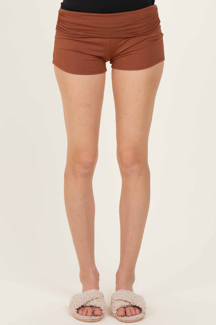 woman wearing brown high-waisted shorts with a fitted style and soft fabric, paired with cozy slippers